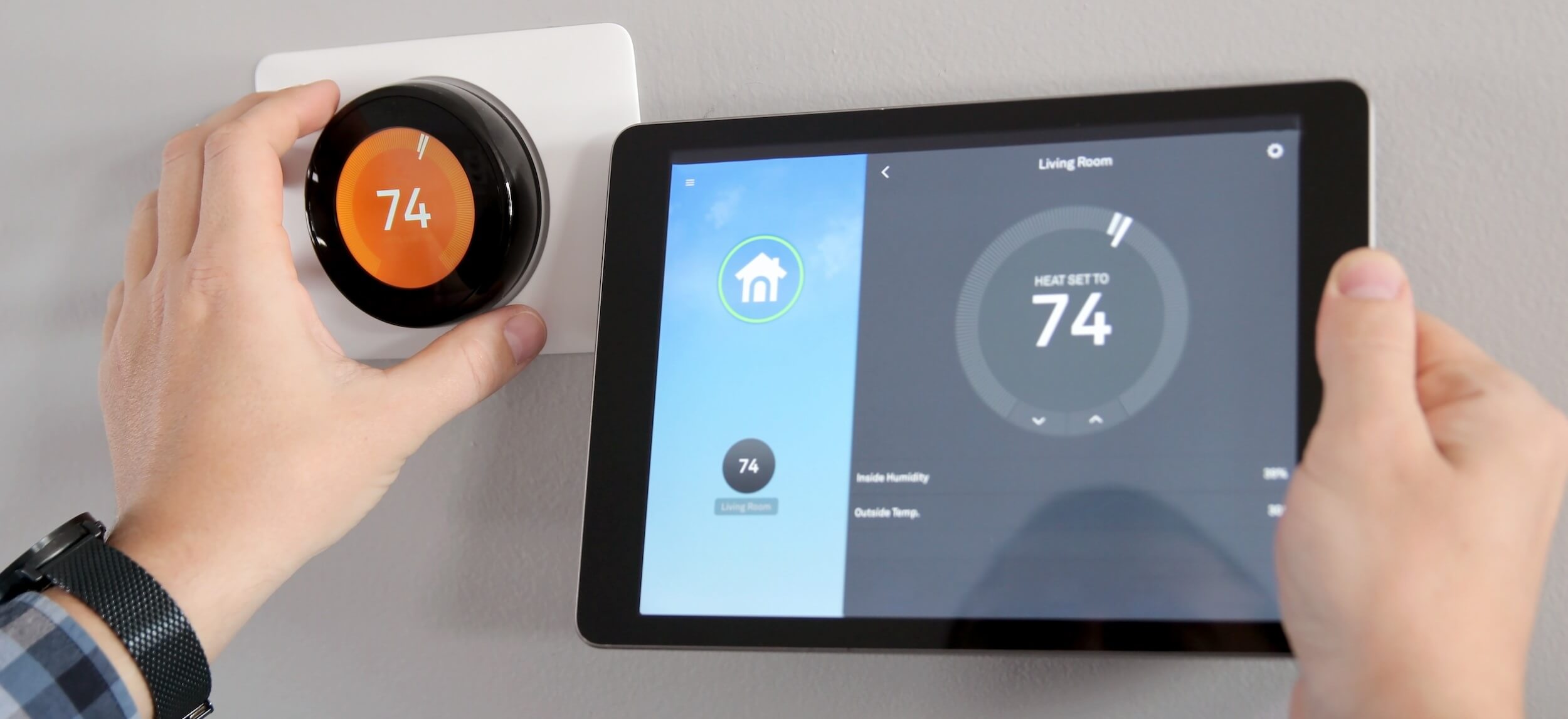 Adjusting a temperature using a tablet with smart home app in modern living room